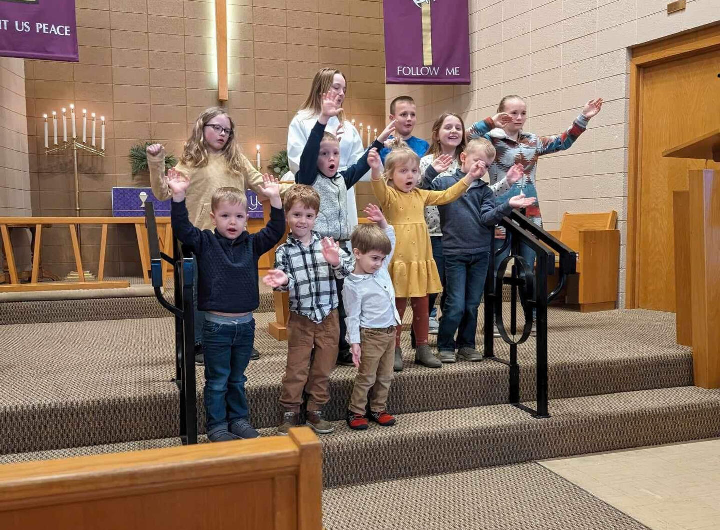 Many children stand in the chancel of Trinity Lutheran Church in Odebolt, Iowa during a children's program.